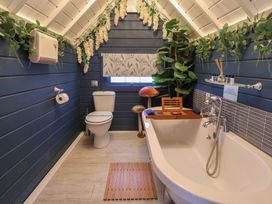 A bathroom with a bathtub and toilet at Applejacks Orchard in Holywell
