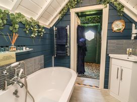 A bathroom with a bathtub and vanity at Applejacks Orchard in Holywell