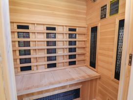 A sauna interior with seating bench and heat panels at Applejacks Orchard Holywell