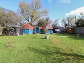 A garden with a blue shed and seating areas at Applejacks Orchard in Holywell