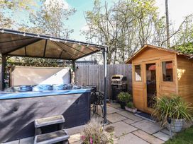 A garden with a hot tub, gazebo, and garden shed at Applejacks Orchard, Holywell