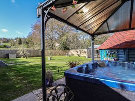 A garden with a hot tub and gazebo at Applejacks Orchard in Holywell