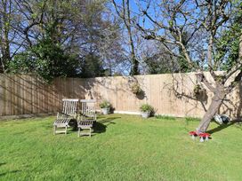 A garden with deck chairs and trees at Applejacks Orchard in Holywell