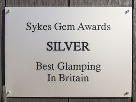 A sign indicating an award for best glamping at Applejacks Orchard in Holywell