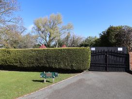 An entrance gate with a sign and a hedge at Applejacks Orchard in Holywell