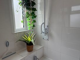 A bathroom with a plant and window at Waves End in Mevagissey