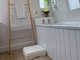 A bathroom with a toilet, sink, and bath at Waves End in Mevagissey