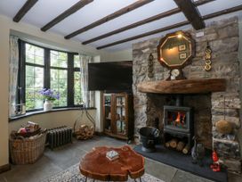A living room with a fireplace and wooden furniture at Windyridge Gwaenysgor near Prestatyn
