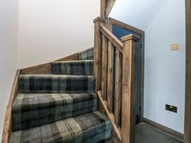 A staircase with a wooden handrail and carpet at Windyridge Gwaenysgor near Prestatyn