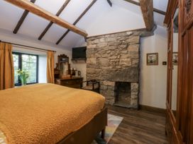 A bedroom with a stone fireplace and wooden furniture at Windyridge, Gwaenysgor, near Prestatyn