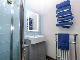 A bathroom with a shower, sink, and towels at Windyridge in Gwaenysgor, near Prestatyn