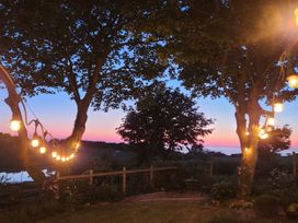 A garden with trees and string lights at Windyridge in Gwaenysgor, near Prestatyn