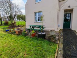 An outdoor area with flower pots and a table at Mallards Rest in Llandwrog near Bontnewydd, Gwynedd
