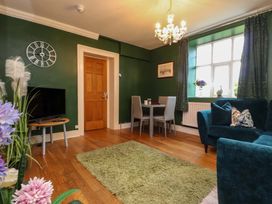 A living room with a sofa and dining table at Mallards Rest in Llandwrog near Bontnewydd, Gwynedd