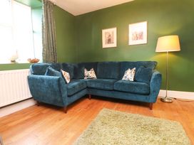 A living room with a sofa and lamp at Mallards Rest in Llandwrog near Bontnewydd, Gwynedd