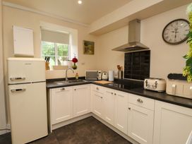 A kitchen with appliances and cabinets at Mallards Rest in Llandwrog near Bontnewydd, Gwynedd