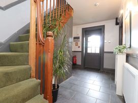 A hallway with stairs and a door at Mallards Rest in Llandwrog near Bontnewydd, Gwynedd