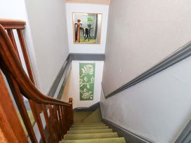 A staircase with a wooden handrail leading to a landing at Mallards Rest in Llandwrog near Bontnewydd, Gwynedd