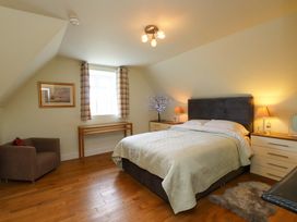 A bedroom with a bed and a chair at Mallards Rest in Llandwrog near Bontnewydd, Gwynedd