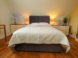 A bedroom with a bed and nightstands at Mallards Rest in Llandwrog near Bontnewydd, Gwynedd