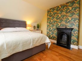 A bedroom with a bed and bedside lamp at Mallards Rest in Llandwrog near Bontnewydd, Gwynedd
