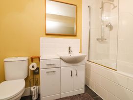 A bathroom with a toilet, sink, shower, and bathtub at Mallards Rest in Llandwrog near Bontnewydd, Gwynedd