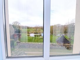 An outdoor view from a window featuring a pond and trees at Mallards Rest Llandwrog near Bontnewydd Gwynedd