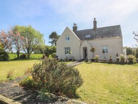 A house with a garden and flower pots at Mallards Rest in Llandwrog near Bontnewydd, Gwynedd