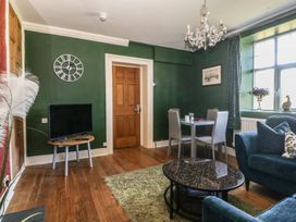 A living room with a television and dining table at Mallards Rest in Llandwrog near Bontnewydd, Gwynedd