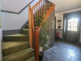 A hallway with a staircase and plant at Mallards Rest in Llandwrog near Bontnewydd, Gwynedd