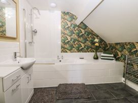 A bathroom with a bathtub, sink, and towels at Mallards Rest in Llandwrog near Bontnewydd, Gwynedd