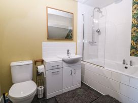 A bathroom with a sink, toilet, bathtub, and shower at Mallards Rest in Llandwrog near Bontnewydd, Gwynedd