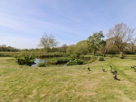A scenic outdoor setting with a pond and trees at Mallards Rest in Llandwrog near Bontnewydd, Gwynedd