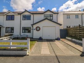 A house with a garage and driveway at Wingelock in Rhosneigr