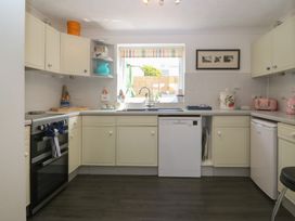 A kitchen with an oven, sink, and dishwasher at Wingelock in Rhosneigr
