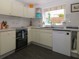 A kitchen with cabinets, oven, sink, and dishwasher at Wingelock in Rhosneigr
