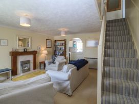 A living room with a fireplace and bookshelves at Wingelock in Rhosneigr