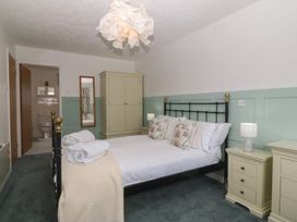 A bedroom with a bed and wardrobe at Wingelock in Rhosneigr
