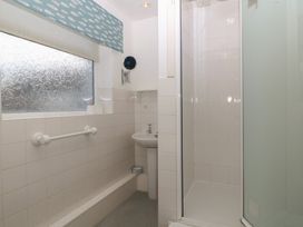 A bathroom featuring a shower, sink and towel rail at Wingelock in Rhosneigr