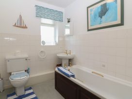 A bathroom with a bathtub and sink at Wingelock in Rhosneigr