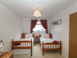 A bedroom with two beds and a bedside table at Wingelock in Rhosneigr