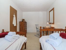 A bedroom with two beds and a dresser at Wingelock in Rhosneigr