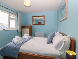 A bedroom with a bed and dresser at Wingelock in Rhosneigr