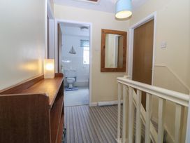 A hallway with a staircase and mirror at Wingelock in Rhosneigr