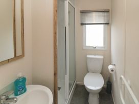 A bathroom with a toilet shower sink and mirror at No30 Elm Rise in Gristhorpe near Filey