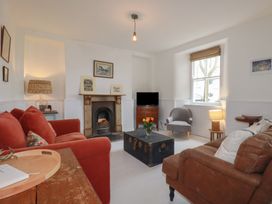 A living room with a sofa and armchair at 84 Fore Street