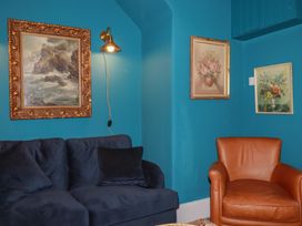 A living room with blue walls and furniture at 84 Fore Street