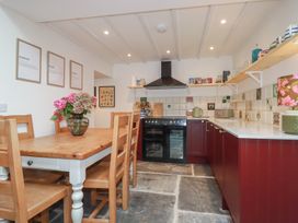 A kitchen with a dining table and wooden chairs at 84 Fore Street