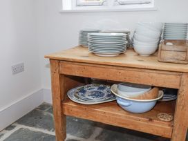 A wooden table with stacked plates and bowls in a kitchen at 84 Fore Street
