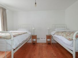 A bedroom with two beds and bedside tables at 84 Fore Street 